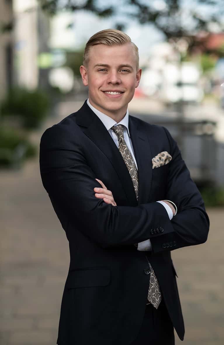 Ung man i kostym poserar för jobbfoto